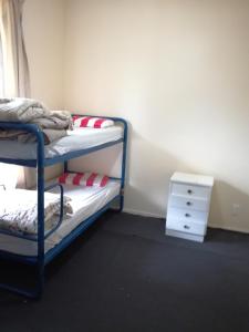 a bedroom with two bunk beds and a night stand at Slalom Lodge in Raurimu Spiral