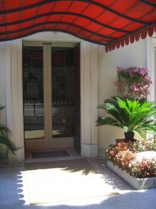 an entrance to a building with a red umbrella at Hotel Claila in Francavilla al Mare