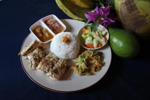 une assiette de denrées alimentaires contenant du riz et d’autres denrées alimentaires dans l'établissement Blue Star Bungalows & Cafe, à Amed