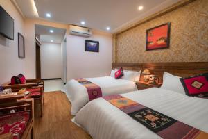 a hotel room with two beds and a television at Sapa Luxury Hotel in Sapa