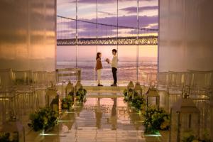 eine Braut und ein Bräutigam stehen vor der Golden Gate Bridge in der Unterkunft Hotel Setre Kobe Maiko in Kōbe