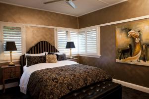 um quarto com uma cama e um quadro na parede em Mountain Whispers The Gatsby em Katoomba