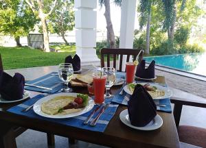 a wooden table with plates of food on it at Diya Dahara Lake Resort in Tissamaharama