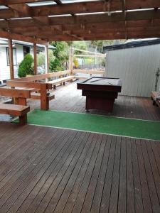 eine Terrasse mit Bänken und einer Tischtennisplatte in der Unterkunft Slalom Lodge in Raurimu Spiral