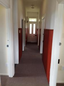 un corridoio di una stanza vuota con una porta e un corridoio di Slalom Lodge a Raurimu