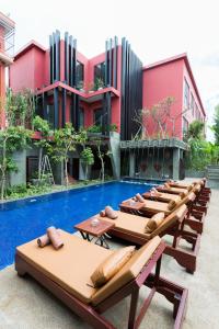 a row of chaise lounges in front of a resort at Golden Temple Villa in Siem Reap