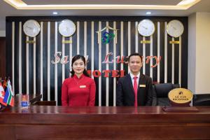 a man and a woman standing behind a desk at Sapa Luxury Hotel in Sa Pa