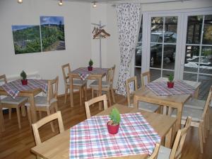 un restaurante con mesas de madera y sillas con plantas. en Weingut & Gästehaus Engelmann-Schlepper, en Martinsthal