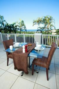 una mesa y sillas en un patio con vistas al océano en Seaview Manor Exquisite Bed & Breakfast, en Durban