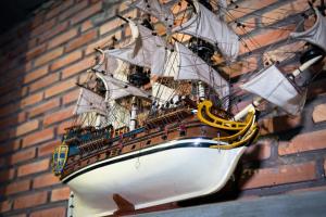 a model ship hanging on a brick wall at Maison Gen Angkor in Siem Reap