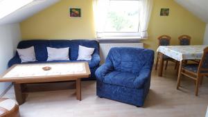 sala de estar con sofá azul y mesa en Haus Jägersruh, en Nagel