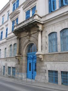un bâtiment avec une porte bleue sur son côté dans l'établissement Hotel Veli Jože, à Pula