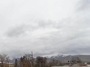 a cloudy sky with snow covered mountains in the background at Flamingo Hotel in Karakol