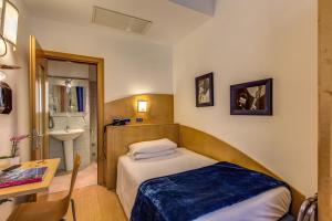 a small bedroom with a bed and a sink at Hotel Franklin Feel The Sound in Rome