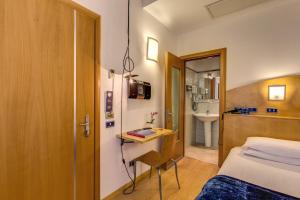 a hotel room with a bed and a bathroom at Hotel Franklin Feel The Sound in Rome