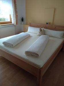 Una cama grande con dos toallas blancas. en Ferienwohnung Gertraud und Peter Geisler, en Finkenberg