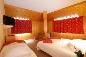 2 łóżka w pokoju z czerwonymi zasłonami w obiekcie Carlit w mieście Font-Romeu