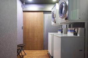 a kitchen with a washer and a wooden door at Tomorrow Hotel in Taipei