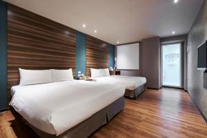 a hotel room with two beds and a television at Tomorrow Hotel in Taipei