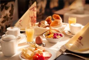 a table with a breakfast of eggs and bread and orange juice at Hotel am Markt Bacharach in Bacharach