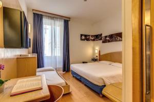 a hotel room with two beds and a tv at Hotel Franklin Feel The Sound in Rome