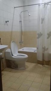 a bathroom with a toilet and a tub and a shower at Nozol Mena 109 by Al Azmy in Riyadh