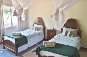 a bedroom with two beds and a window at Ouhave Country Home in Imkerhof