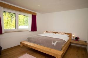 sypialnia z łóżkiem i oknem w obiekcie Apartmenthaus Lieselotte w mieście Ramsau am Dachstein