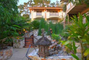 a garden in front of a house with a small fountain at Tradewinds Carmel in Carmel