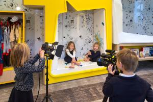 two little girls taking pictures of themselves in a mirror at Hôtel Barrière Le Gray d'Albion in Cannes