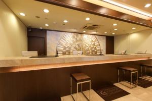 a lobby with a bar with two stools at Kobe Sannomiya Tokyu REI Hotel in Kobe