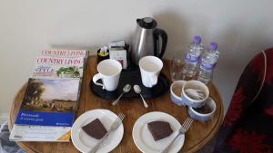 uma mesa de madeira com uma mesa com alguns alimentos e bebidas em Kilsham Farm em Petworth