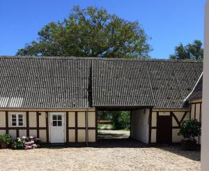 un edificio marrone e bianco con garage di Ferielejlighed på Rødkærgård a Kerteminde