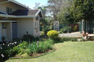 einen Garten vor einem Haus mit Blumen in der Unterkunft Taunton House B&B in Pietermaritzburg