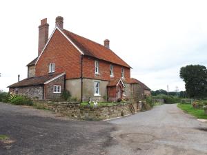 une vieille maison en briques sur le côté d'une route dans l'établissement Kilsham Farm, à Petworth