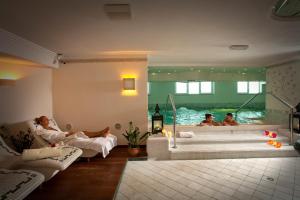 three people in a room with a bath tub at Hotels Vidi Miramare & Delfino in Lido di Jesolo