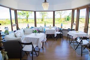 a dining room with tables and chairs and windows at Cherrytree House B&B in Moville
