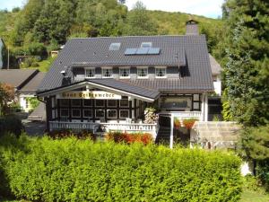 een huis met een restaurant met een dak bij Pension Haus Seidenweber in Schmallenberg