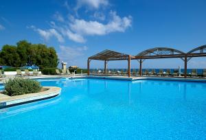 een groot zwembad met blauw water in een resort bij Aldemar Knossos Royal in Chersonissos