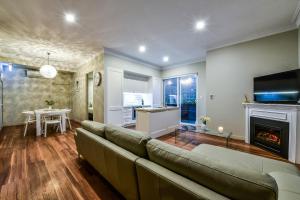 a living room with a couch and a fireplace at Aloha Central Luxury Apartments in Mount Gambier