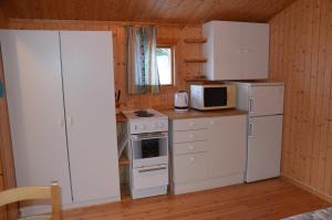a kitchen with a white refrigerator and a stove at Käringsund Resort Camping in Eckerö +20 photos