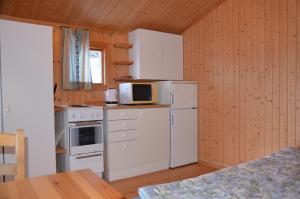 a kitchen with a white refrigerator and a microwave at Käringsund Resort Camping in Eckerö