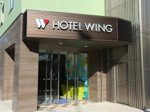 un letrero del ala del hotel en el lateral de un edificio en Hotel Wing International Select Higashi Osaka en Osaka