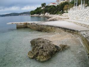 Una roca en el agua junto a una playa en Blue Sensation, en Okrug Donji