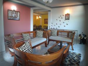 a living room with chairs and a table and a dining room at Jaya Tomodachi in Kandy