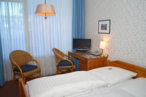 a hotel room with a bed and a desk and a television at Motel Hamburg in Hamburg