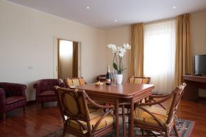 a living room with a wooden table and chairs at Appia Antica Hotel in Corato