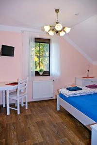 1 Schlafzimmer mit 2 Betten, einem Tisch und einem Fenster in der Unterkunft Penzion Pulčínské Skály in Pulčín