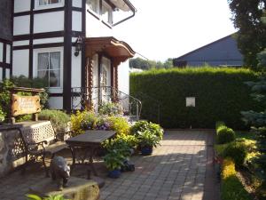 eine Terrasse mit einem Tisch und einer Bank vor einem Haus in der Unterkunft Ferienwohnungen Seidenweber in Schmallenberg