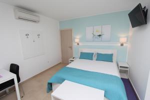 a bedroom with a blue and white bed and a desk at Studio Emanuel in Rovinj